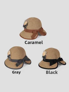 Three straw sun hats in caramel, gray, and black with bow details and fine weave texture