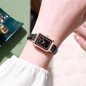 Close-up of vintage square watch with black leather strap and rose gold metal case