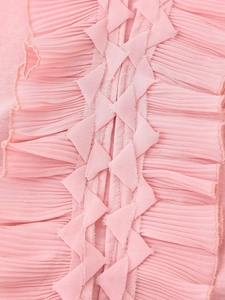 Macro detail of pink chiffon fabric with textured pleats and woven drawstring design