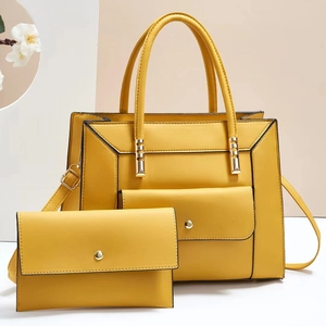 Detail of yellow PU leather handbag and matching envelope bag with gold hardware set