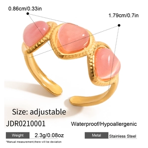 Detail of adjustable golden stainless steel wave ring with pink cat-eye gemstones