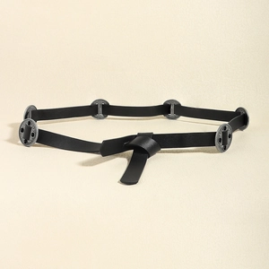 Detail of vintage black belt with silver metal discs in a stylish knotting style