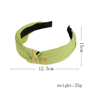 Detail view of grass green ribbed knotted headband with size dimensions 15x12.5x3.5cm