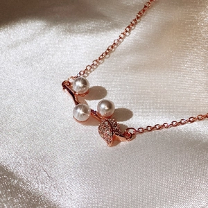 Close-up of rose gold rose petal necklace with white pearls and micro-pave zircons