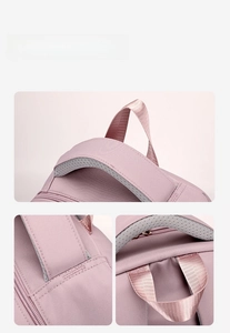 Detail of pink backpack showing padded top handle and breathable mesh shoulder straps