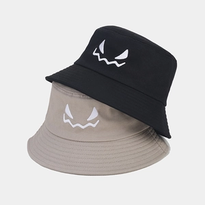 Detail shot of Halloween embroidered face pattern on black and khaki cotton bucket hats