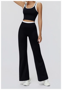 Detail of high-waist wide-leg yoga pants with contrast white trim and black matte fabric