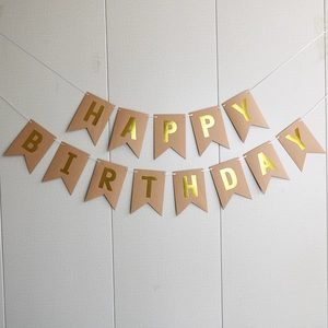 Detail of kraft paper Happy Birthday banner with gold foil swallowtail letter bunting