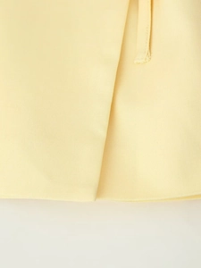Vue macro du tissu en sergé jaune clair et détails de couture sur la veste de costume