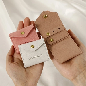 Close-up of pink and grey microfiber jewelry pouches with gold snap buttons