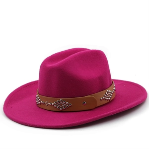 Detail of fuchsia wool fedora featuring a brown leather band with silver metal rivets