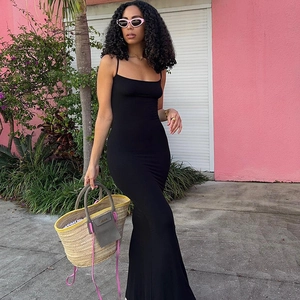 Detail view of a black sleeveless bodycon maxi dress with slim straps in a street setting