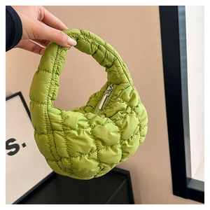 Close-up of light green quilted cloud bag with puffy texture and mini top handle design