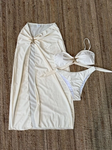 Détail du bikini ivoire avec breloques d'étoile de mer dorées et paréo en maille
