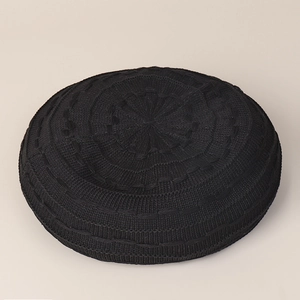 Detailed top view of black knitted beret showing radial weave patterns and fine texture