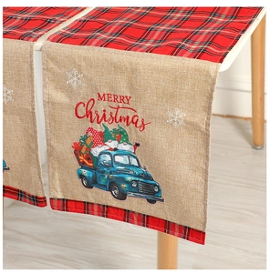 Detail of Christmas table runner with red plaid burlap fabric and festive truck design