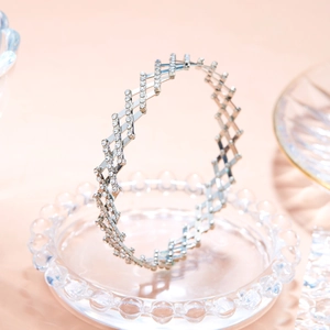 Detail of silver-tone telescopic ring transforming into a sparkling crystal bracelet