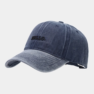 Close-up of black HELLO embroidery on washed blue denim vintage baseball cap