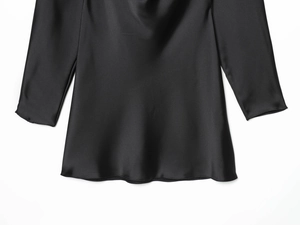 Detail of black silk satin fabric showing smooth texture and draped neck design