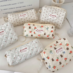 Variété de trousses de maquillage et de crayons matelassées avec motifs fleurs et ours