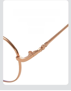 Detail of rose gold metal eyewear frame showing the reinforced engraved hinge