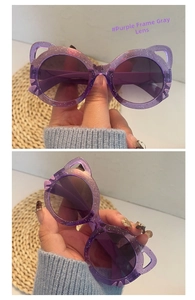 Detail view of purple glitter cat-ear sunglasses for kids with grey UV protection lenses