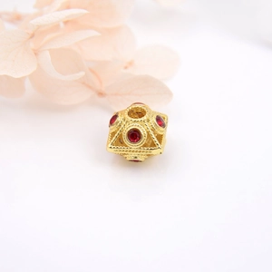 Macro shot of 18k gold plated square hollow bead with red gemstone for DIY jewelry making