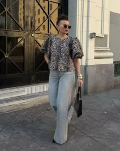 Close-up of leopard print puff sleeve top styled with light blue jeans and black bag