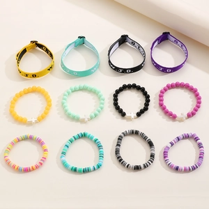 Detailed flat lay of 12 mixed WWJD woven, beaded and Heishi style bracelets in vivid colors