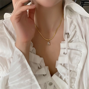 Detail of emerald green rectangular stone on gold snake chain necklace for women