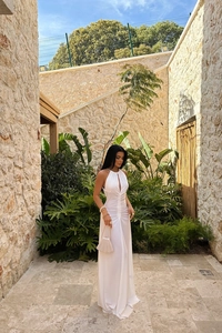 Detail of white halter neck dress featuring front cutout and pleated drawstring waist