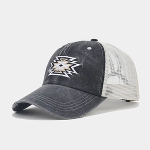 Detail of vintage washed grey cotton cap with ethnic embroidery and breathable white mesh