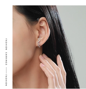 Detail of s925 silver wave earrings with micro-inlaid zircons on model ear