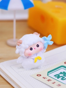 Close-up of cute resin sheep figurine with blue windmill for desk or car decoration