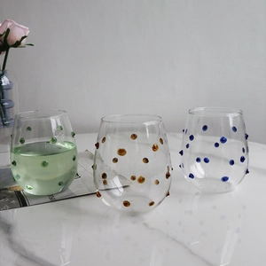 Detail of creative glassware with colorful raised dots in green amber and blue