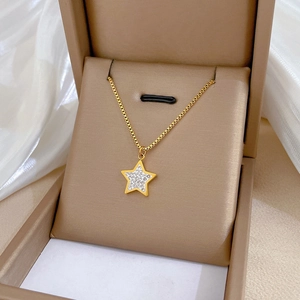 Detail of star pendant necklace with gold chain and pave crystals on a jewelry box