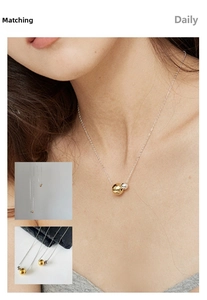 Detail of minimalist two-tone beads necklace on model with polished gold and silver finish