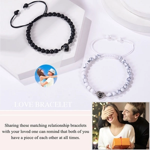 Detail view of couple bead bracelets with heart projection stone on geometric stand