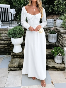 Detail of elegant white long sleeve square neck dress with tie waist detail in garden