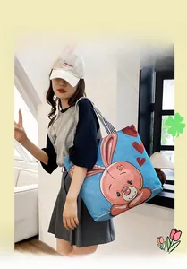 Detail of blue tote bag with pink cartoon rabbit print and striped handles