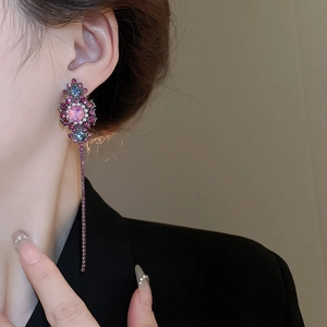 Macro view of vintage floral tassel earrings with pink gems and purple crystals