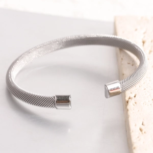 Macro detail of 7mm stainless steel mesh cuff bracelet with polished silver end caps