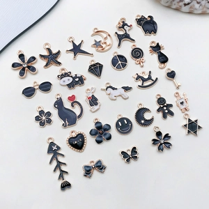 Macro shot of assorted black enamel and gold alloy charms including animals and stars