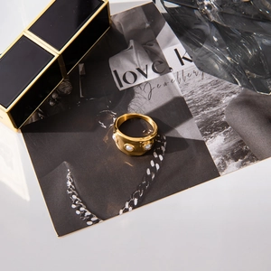 Gros plan sur la bague en acier inoxydable doré 18K avec texture irrégulière et perles