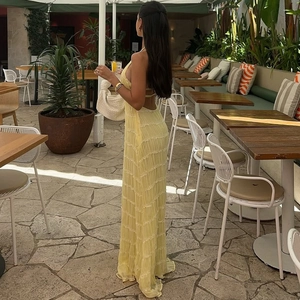 Detail of yellow backless pleated maxi dress with textured fabric in a resort setting