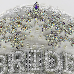 Detailed view of white sequins and pearls with BRIDE rhinestone lettering on bridal captain hat