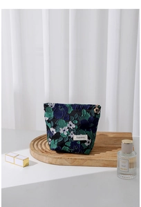 Macro detail of dark blue floral jacquard fabric with elegant golden petal zipper pull