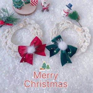 Detail of handmade knit Christmas pet collar with gold bow and soft fur ball