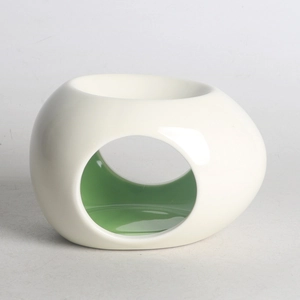 Abstract white oval ceramic essential oil burner with green interior and side cutouts