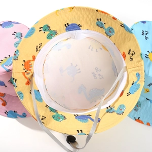 Detail view of cartoon dinosaur bucket hats featuring breathable mesh lining and windproof cord